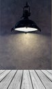 Empty Wooden Perspective Platform with Lamp Shade from Modern Black Metal Lamp Hanging on Gray Wall Background with Copyspace used