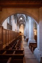 Empty wooden pews or chairs inside Gothic, medieval church in Europe. Wide angle, no people