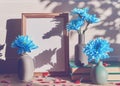 Empty wooden photo frame, blue chrysanthemums in vases, shapes in the form of hearts are on a light wooden background. Royalty Free Stock Photo