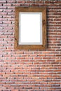 Empty wooden picture frame hanging on a brick wall. Royalty Free Stock Photo