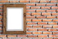 Empty wooden picture frame hanging on a brick wall. Royalty Free Stock Photo