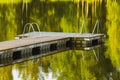 Empty wooden pier on a quiet lake in the summer morning Royalty Free Stock Photo