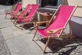 Empty wooden pink deck chairs near the cafe in summer. Tables and deckchairs at sidewalk cafe. Touristic setting, cafe table, Royalty Free Stock Photo