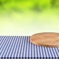 Empty wooden pizza board on blue checkered tablecloth. Royalty Free Stock Photo