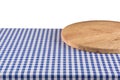 Empty wooden pizza board on blue checkered tablecloth.