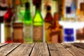 Empty wooden planks against various alcohol bottles in a bar or restaurant. Bar advertisement mockup image Royalty Free Stock Photo