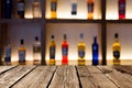 Empty wooden planks against various alcohol bottles in a bar or restaurant. Bar advertisement mockup image Royalty Free Stock Photo