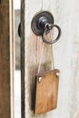 Empty wooden plate on metal door knob. Place for logo, text. Don`t disturb sign