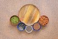 Empty wooden plate and semicircular frame various seeds in a bowl on a brown stone background. Seeds of flax, chia, pumpkin,