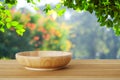 Empty wooden plate on table over blur trees with bokeh backgroun Royalty Free Stock Photo