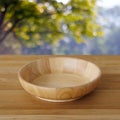 Empty wooden plate on table over blur trees with bokeh backgroun Royalty Free Stock Photo