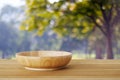 Empty wooden plate on table over blur trees with bokeh backgroun Royalty Free Stock Photo