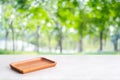 Empty wooden plate on white table over blur green trees nature with bokeh background, Blank wood dish for food display montage Royalty Free Stock Photo