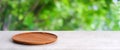 Empty wooden plate on white table over blur green trees nature with bokeh background, Blank wood dish for food display montage Royalty Free Stock Photo