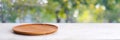 Empty wooden plate on white table over blur green trees nature with bokeh background, Blank wood dish for food display montage Royalty Free Stock Photo