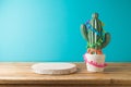 Empty wooden podium with cactus decoration on wooden table over blue background. Cinco de Mayo Mexican holiday celebration