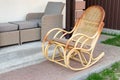 Empty wooden rattan rocking chair on house terrace backyard outdoors. Peaceful lifestyle home exterior Royalty Free Stock Photo