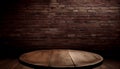 Empty wooden round table top with abstract old brick wall background. To create product display.