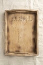 Empty wooden serving box with handles with the inscription MENU. Food and catering concept