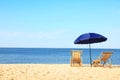 Empty wooden sunbeds and umbrella on sandy shore. Beach Royalty Free Stock Photo