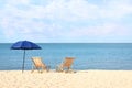 Empty wooden sunbeds and umbrella on sandy shore. Beach Royalty Free Stock Photo