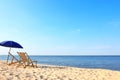 Empty wooden sunbeds and umbrella on sandy shore. Beach Royalty Free Stock Photo