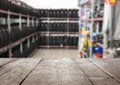 Empty wooden surface and view of car tires in auto store, closeup. Space for text