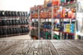 Empty wooden surface and blurred view of car tires in auto store. Space for text