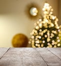 Empty wooden surface and blurred view of Christmas tree in room, space for text. Interior design Royalty Free Stock Photo