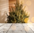 Empty wooden surface and blurred view of Christmas tree in room, space for text. Interior design Royalty Free Stock Photo