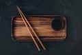Empty wooden sushi plate with chopsticks on dark black stone background Royalty Free Stock Photo