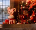 Empty wooden table on the background of Christmas tree, fireplace, santa socks, boxes with gifts, a big santa sock with Christmas
