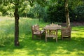 Empty wooden table with bench and chairs in garden Royalty Free Stock Photo