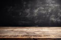 empty wooden table with black grunge wall in the background Royalty Free Stock Photo