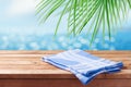 Empty wooden table with blue tablecloth over tropical beach bokeh background. Summer mock up for design and product display Royalty Free Stock Photo