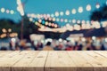 Empty wooden table and blurred background at night market festival people walking on road with copy space, display montage for Royalty Free Stock Photo