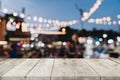 Empty wooden table and blurred background at night market festival people walking on road with copy space, display montage for Royalty Free Stock Photo