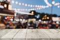 Empty wooden table and blurred background at night market festival people walking on road with copy space, display montage for Royalty Free Stock Photo