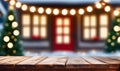 Empty wooden table, blurred Christmas decorated house exterior Royalty Free Stock Photo