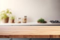 Empty wooden table and blurred modern minimalist kitchen interior with wooden table and green plants background Royalty Free Stock Photo