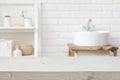 Empty wooden table and blurred view of bathroom sink interior Royalty Free Stock Photo