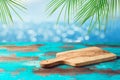 Empty wooden table with cutting board over tropical beach with palm leaves bokeh background. Summer mock up for design and Royalty Free Stock Photo