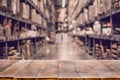 Empty wooden table on defocused blurred boxes on rows of shelves Royalty Free Stock Photo