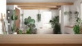 Empty wooden table, desk or shelf with blurred view of bathroom with bathtub and many houseplants. Urban jungle interior design Royalty Free Stock Photo