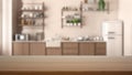 Empty wooden table, desk or shelf with blurred view of modern kitchen close up, cabinets and shelves, refrigerator and appliances