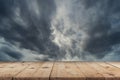 Empty wooden table and dramatic thunder storm clouds at dark sky