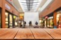 Empty wooden table in front of abstract blurred background of shopping mall Royalty Free Stock Photo