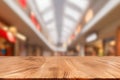 Empty wooden table in front of abstract blurred background of shopping mall Royalty Free Stock Photo