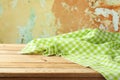 Empty wooden table with green checked tablecloth over rustic wall background Royalty Free Stock Photo