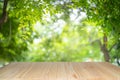 Empty wooden table on green nature background with beauty bokeh under sunlight Royalty Free Stock Photo